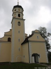 Kirchturm der Frauenbergkirche mit Zwiebelhaube im schwäbischen Barock, rechts davon ein Eingang