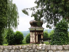 Schlangenbrunnen, Überdachter Brunnen im Barockstil mit Fachwerk im Park, davor eine kleine Mauer